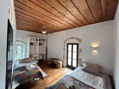 two beds in a room with a wooden ceiling at Villa ABBA in Plaka
