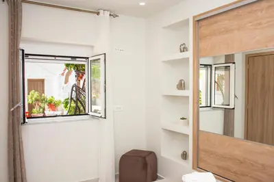 a bathroom with a mirror and a toilet and a window at Garden house in Kissamos