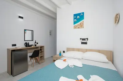 a bedroom with a bed with a desk and a desk at Finikas Resort Sfakia - Seaside Rooms in Loutro