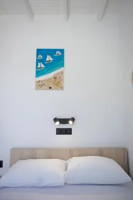 a bedroom with a bed with a picture on the wall at Finikas Resort Sfakia - Seaside Rooms in Loutro