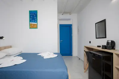 a room with a blue bed and a blue door at Finikas Resort Sfakia - Seaside Rooms in Loutro