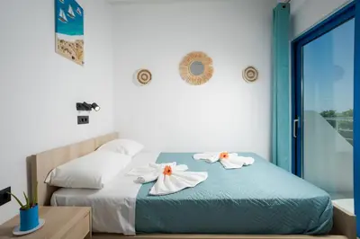 a bedroom with two towels on a bed at Finikas Resort Sfakia - Seaside Rooms in Loutro