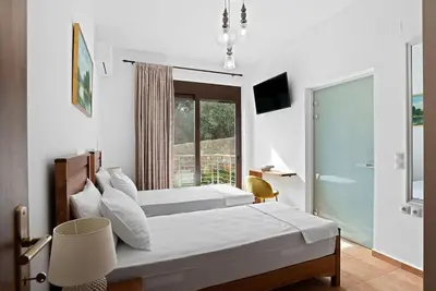 a bedroom with two beds and a large window at Kera Green Villa in Kalyves