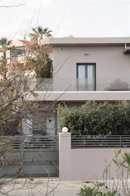 a white house with a fence in front of it at Riviera Seafront Balcony in Evthími