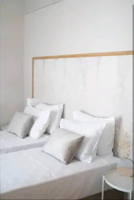 a white bed with white pillows on top of it at Riviera Seafront Balcony in Evthími