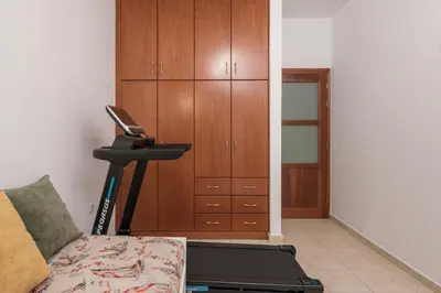 a living room with a treadmill next to a cabinet at Urban Oasis Central in Chania Town