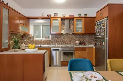 a kitchen with wooden cabinets and stainless steel appliances at Urban Oasis Central in Chania Town