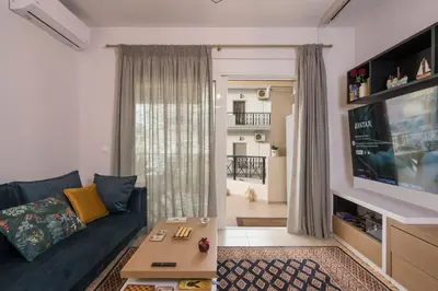 a living room with a blue couch and a tv at Urban Oasis Central in Chania Town