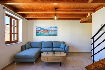 a living room with a blue couch and a table at Old Town Loft with Sea View Roof Terrace and Private Parking in Chania Town
