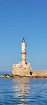 a lighthouse on an island in the water at Old Town Loft with Sea View Roof Terrace and Private Parking in Chania Town