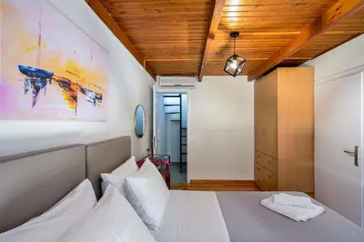 a bedroom with a bed and a wooden ceiling at Old Town Loft with Sea View Roof Terrace and Private Parking in Chania Town