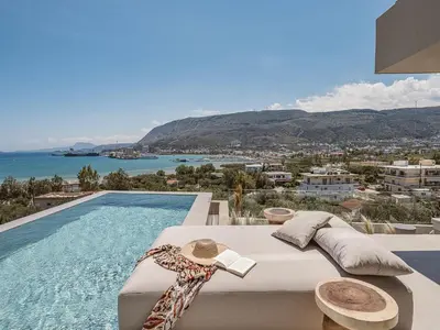 a pool with a bed and a view of the ocean at Villa Albero - Sea View Escape in Souda