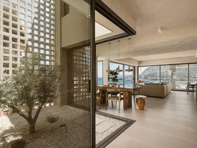 a dining room and living room in a building with a tree at Villa Albero - Sea View Escape in Souda