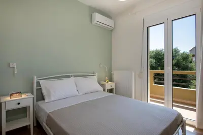 a white bedroom with a bed and a balcony at FRDomus in Daratso