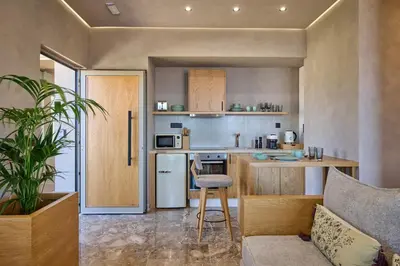 a small kitchen with a table and a chair in a room at Nami Suites - Alenia in Chania Town