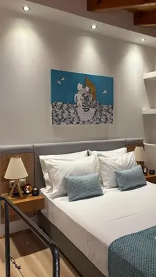 a bedroom with a bed with a painting on the wall at Duplex apartment city center in Chania Town