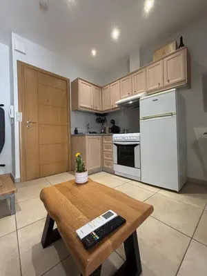 a kitchen with a wooden table and a white refrigerator at Duplex apartment city center in Chania Town