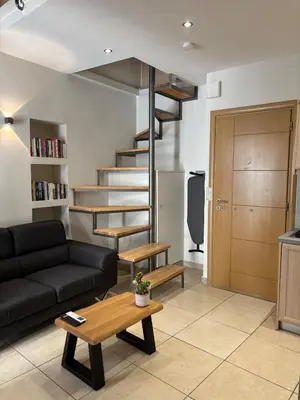 a living room with a couch and a spiral staircase at Duplex apartment city center in Chania Town