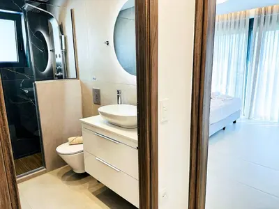 a bathroom with a sink and a toilet and a mirror at Skyline Serenity Villa 10 people 4bedroom 3ba, 3min To Beach in Maleme