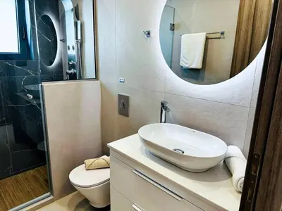 a bathroom with a sink and a toilet and a mirror at Skyline Serenity Villa 10 people 4bedroom 3ba, 3min To Beach in Maleme