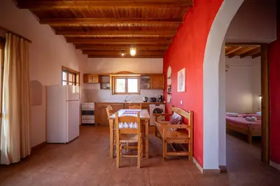 a kitchen with a table and a red wall at BABIS & POPI APARTMENTS in Frangokastello