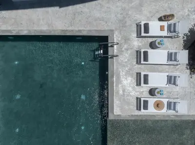 an overhead view of a pool with chairs next to it at Mons Villa in Kalathas