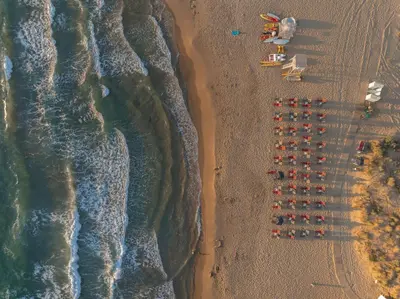 an overhead view of a beach with umbrellas and the ocean at Mons Villa in Kalathas