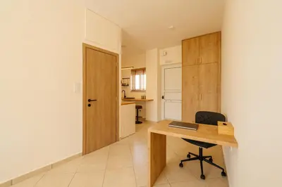 a room with a wooden desk and a chair at El Chacha Studio in Galatás