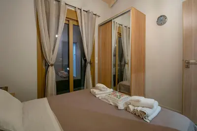 a bedroom with a bed with towels and a mirror at Coastal Haven Your Oasis by the Sea in Análipsis