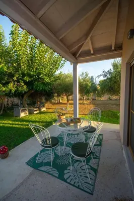 a patio with a table and chairs on a porch at Coastal Haven Your Oasis by the Sea in Análipsis