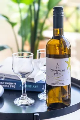 a bottle of wine on a table with a glass at Soul Living City Apartement in Chania Town