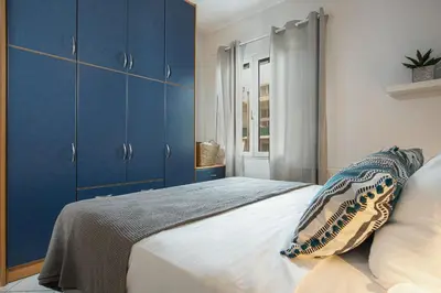 a bedroom with blue cabinets and a large bed at Soul Living City Apartement in Chania Town