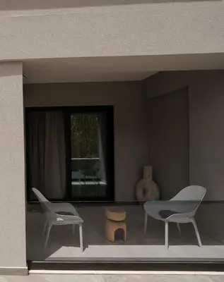 a room with two chairs and a table and a window at Athos Guesthouse in Stalos