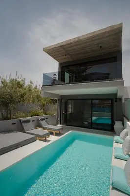 a house with a swimming pool in front of it at Athos Guesthouse in Stalos