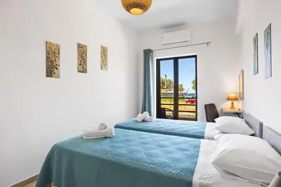 a bedroom with two beds and a window at Sun Beach Apartment in Chania 3 in Chania Town