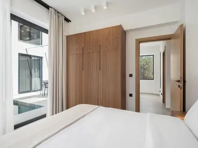 a bedroom with a large bed and a sliding door at P Project Houses in Aghii Apostoli