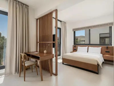a bedroom with a bed and a desk and window at P Project Houses in Aghii Apostoli