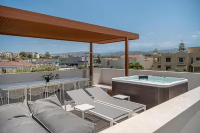a rooftop patio with a hot tub and chairs at P Project Houses in Aghii Apostoli