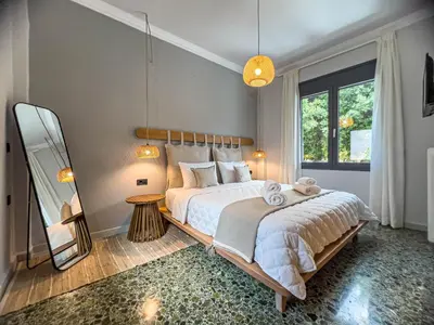 a bedroom with a large bed and a mirror at Apẽron Suite - Downtown Chania in Chania Town
