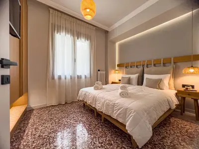 a bedroom with a large bed and a window at Apẽron Suite - Downtown Chania in Chania Town