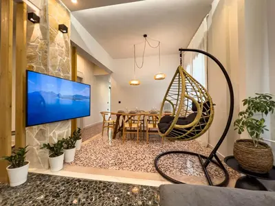 a living room with a large tv and a hanging swing at Apẽron Suite - Downtown Chania in Chania Town