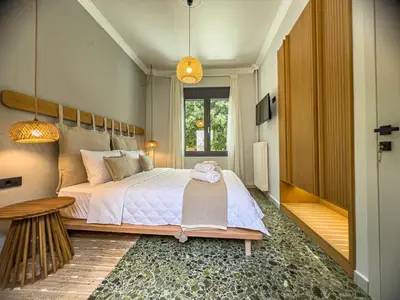 a bedroom with a large bed and a window at Apẽron Suite - Downtown Chania in Chania Town