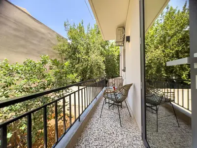 a balcony with chairs and a view of trees at Apẽron Suite - Downtown Chania in Chania Town
