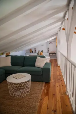 a living room with a green couch and a table at Iris Cretan Mountain Escape in Apothíkai