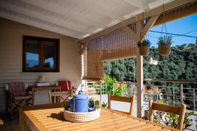 a table with a blue tea pot on top of a balcony at Iris Cretan Mountain Escape in Apothíkai