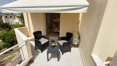 a patio with chairs and an umbrella on a balcony at Sunbeam Retreat in Chania Town
