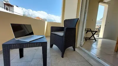 a laptop sitting on a table next to a table with a chair at Sunbeam Retreat in Chania Town