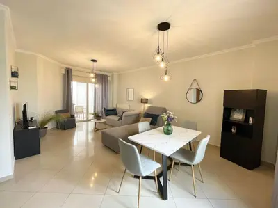 a living room with a table and a couch at Thali central apartment with parking in Chania Town
