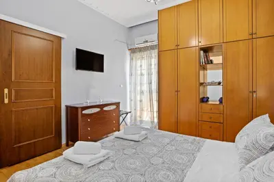 a bedroom with a bed with wooden cabinets and a dresser at Artistic Apartment in Chania in Chania Town