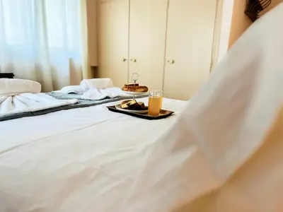 a bed with a tray of food and a glass of orange juice at Sea Breeze Sanctuary-1bd 3pl 1ba - 90m To Sea in Chania Town